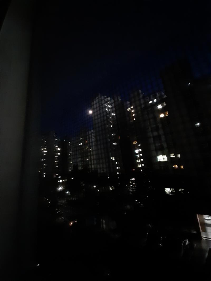 큰 건물 실루엣 바로 옆 허공의 빛이 달이야