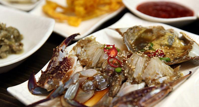 카메라는 테이블 위 간장게장 접시를 크게 확대해 담습니다. 윤기가 좌르르 흐른 게장은 정말로 맛있어 보입니다. 호스트들이 낭랑한 목소리로 '지금