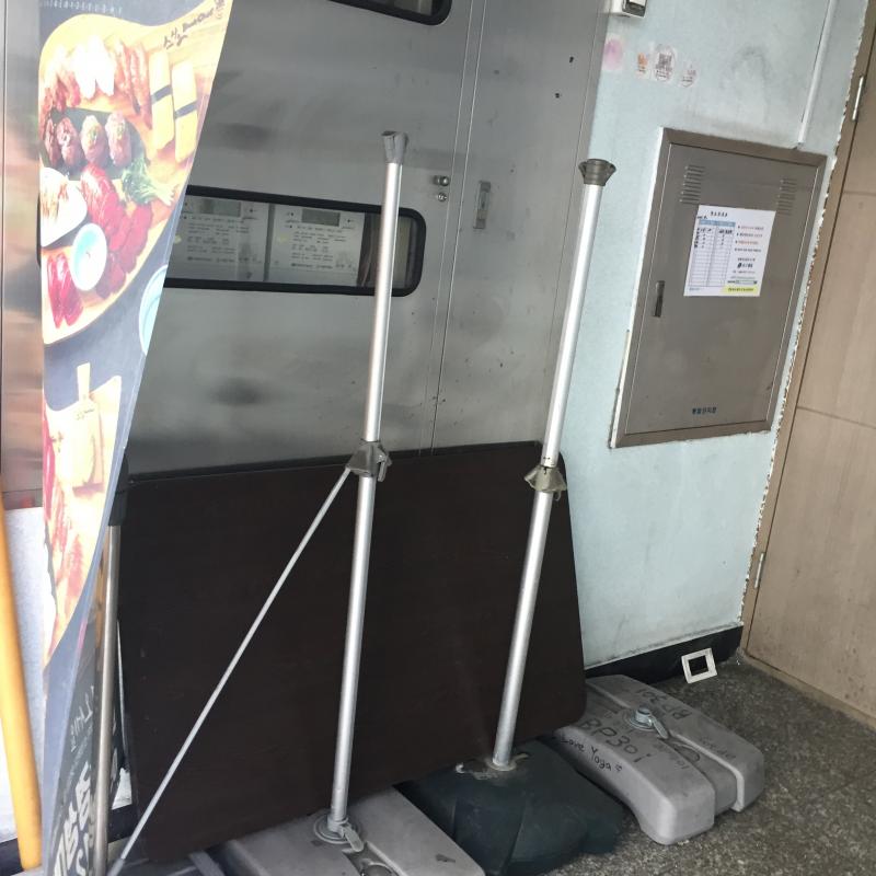 2번출구 4번출구 사이에 seize your day라는 카페 옆에 저런 현수막이 있어. 그 옆에 놓여있는 테이블 뒤에 숨겼어! 10분정도 서있었